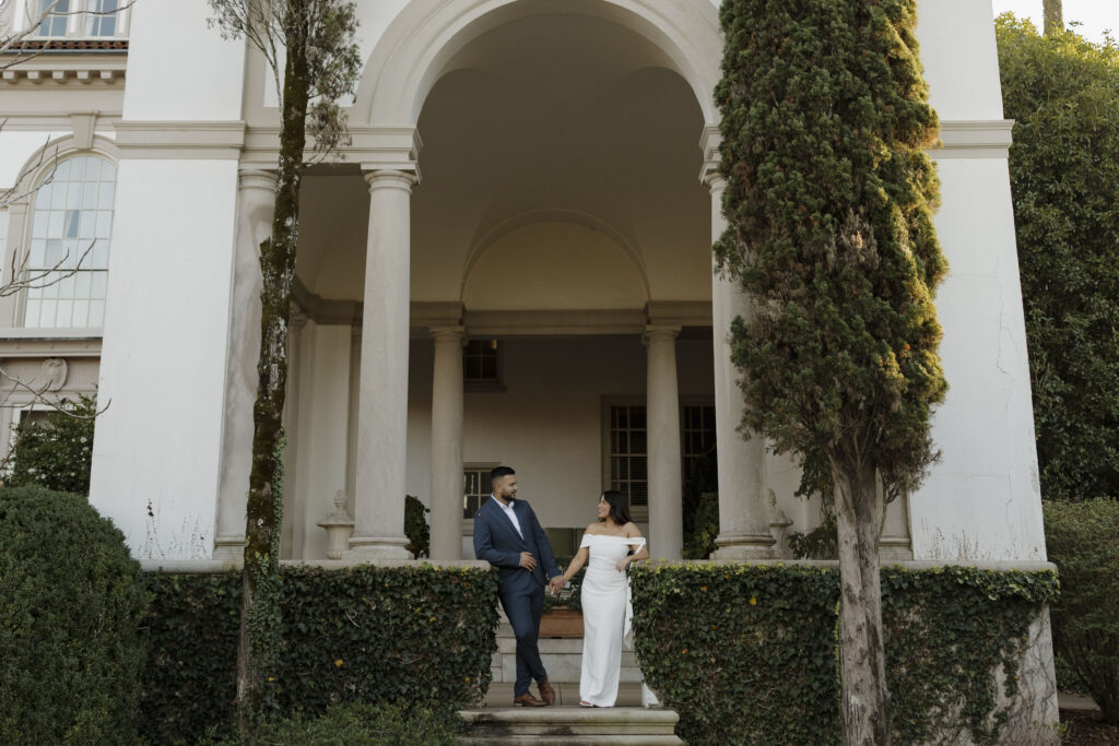 Couple posing in front of the historic estate columns at Hills & Dales Estate in LaGrange, GA