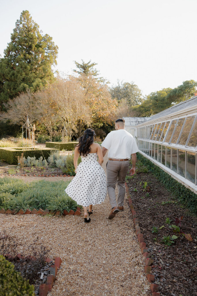Engagement session on garden pathways with lush greenery at Hills & Dales Estate in LaGrange, GA