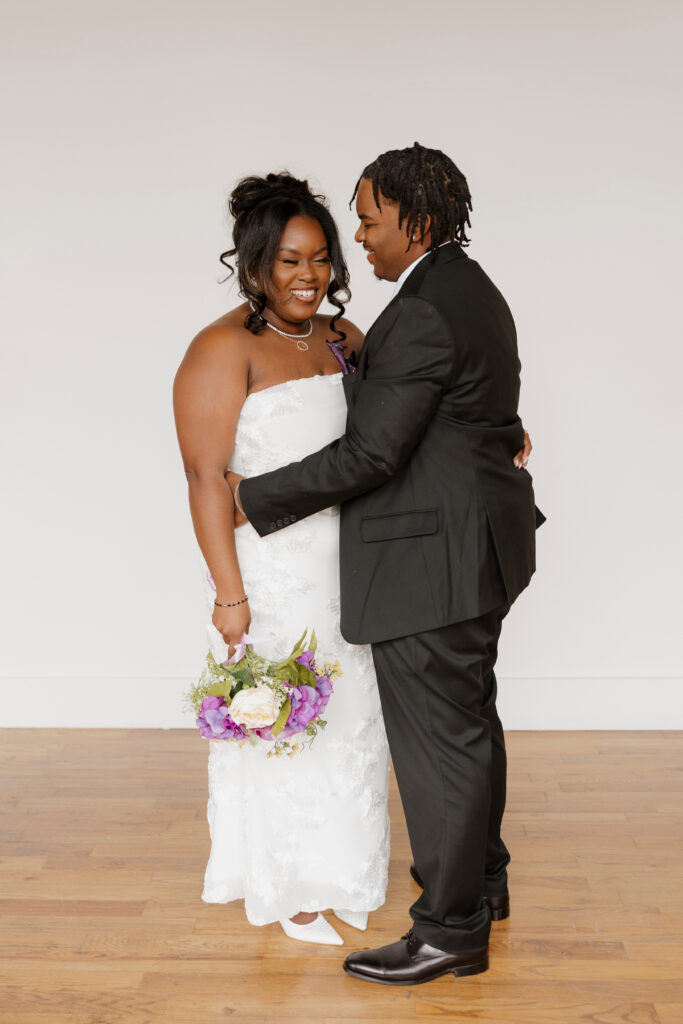 Studio wedding portraits of bride and groom in bright neutral studio space