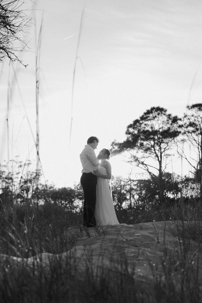 Folly Beach elopement photos at sunset with lighthouse by Leigha Gray Photography